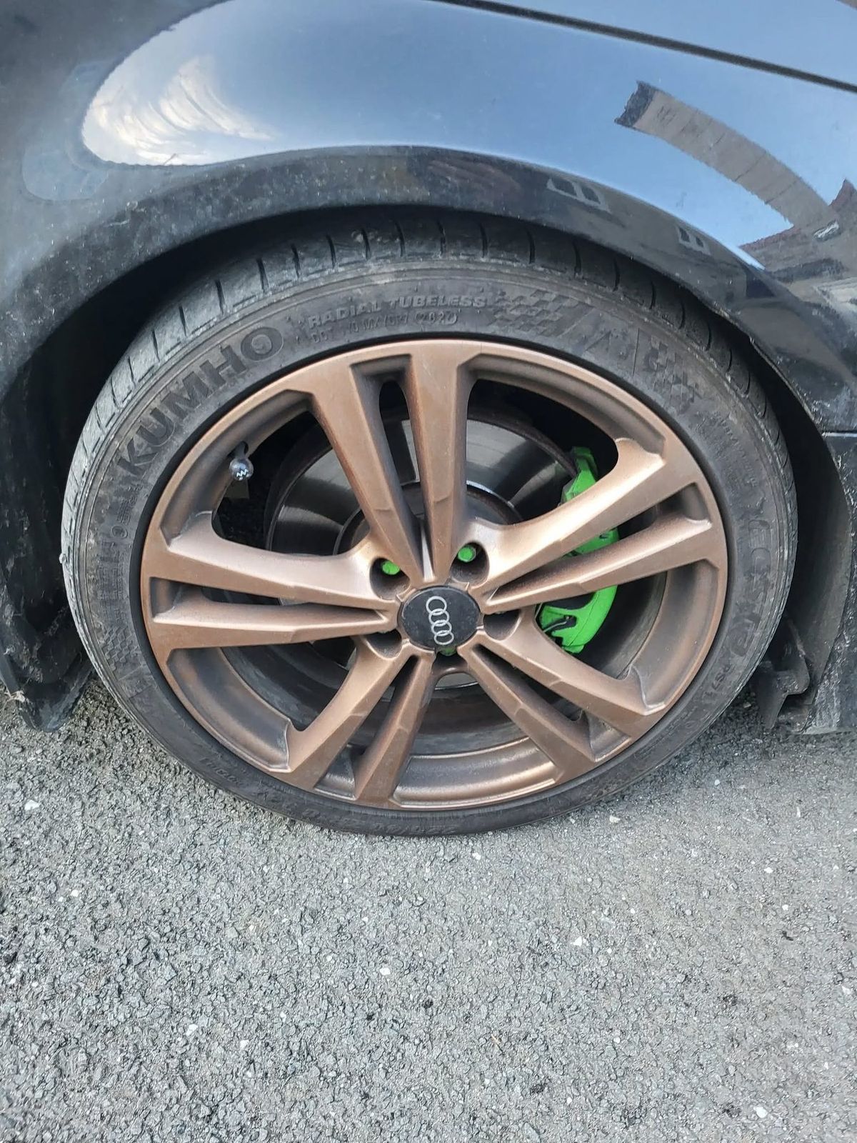 Bronze alloy wheel before valeting, the finish dulled by brake dust and the tyre wall grimy